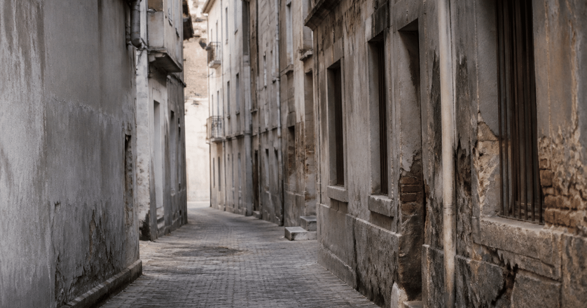 Rues etroites avec immeubles delabres et facades grises endommagees