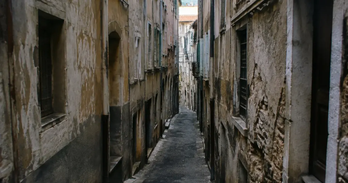 immeubles decrepits surplombant une ruelle etroite et deserte